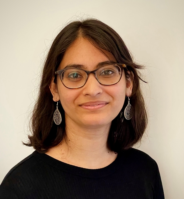 Arunika Das in an off-white background wearing a black shirt.