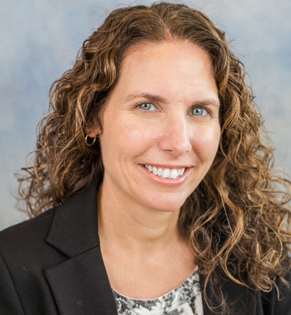 Headshot of woman with wavy brown hair.