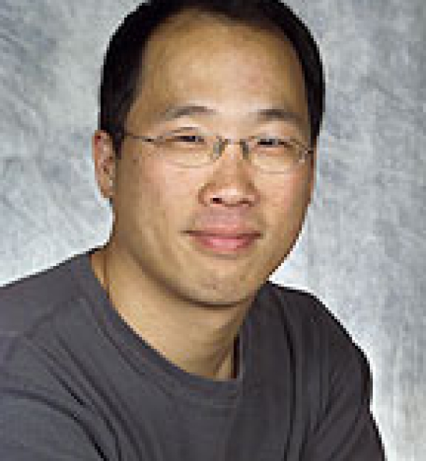 David Lin wearing a dark grey shirt in front of a lighter gray background.