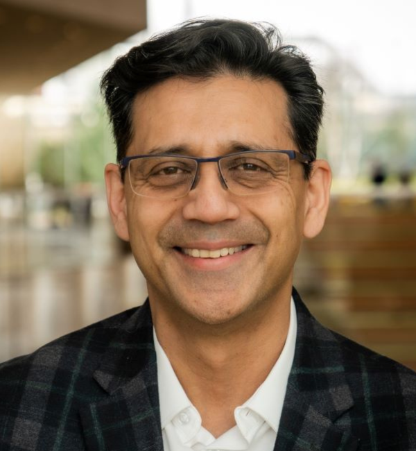 A headshot of a man with glasses sitting inside the CVM atrium. 