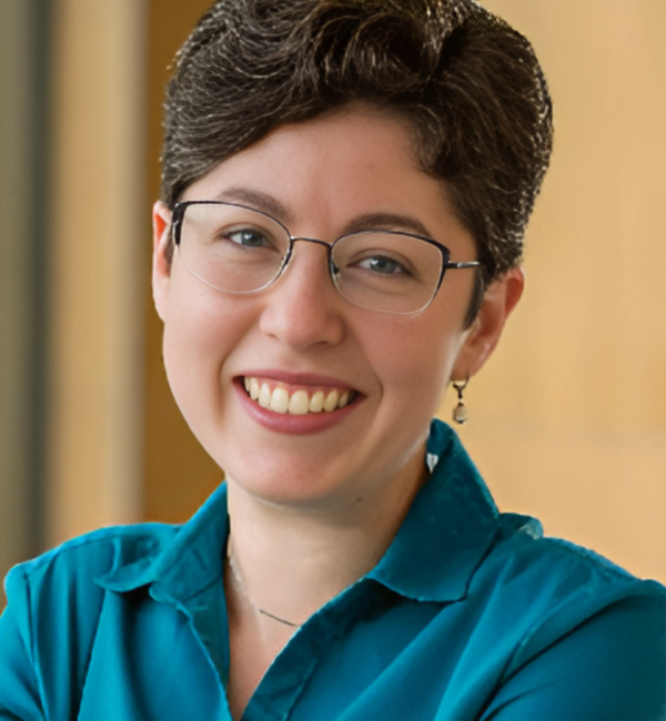 A headshot of a woman with dark hair and glasses. 