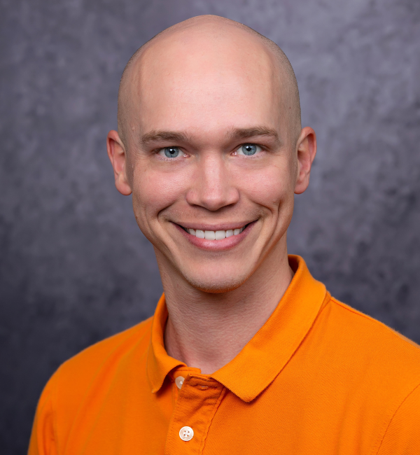 A man with blue eyes and an orange shirt. 