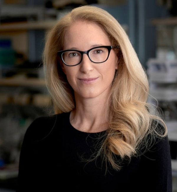 Raina Plowright wearing a black long-sleeved shirt while standing in the lab.