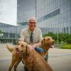 Dr. Rory Todhunter appears with his two dogs in front of the Cornell University College of Veterinary Medicine