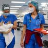 Two veterinary students at a spay event, one carrying a feline patient