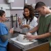 Elia Colón-Mallah pictured with two vet techs examining a cat