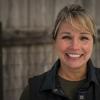 Dr. Lisa Fortier standing in a Cornell Vet jacket with a dark background