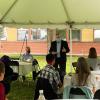 Dean Warnick speaks to a group of faculty in the new department beneath a tent outside the college