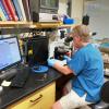 Rod Getchell at a microscope with the Aquatic Animal Health Program
