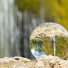 A stock photo of a waterfall reflected in a water droplet