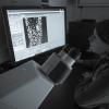 A woman examines a computer screen