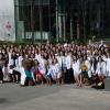 The DVM Class of 2023 poses outdoors with their white coats
