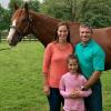 Jorge Colon, his wife and daughter next to a racehorse