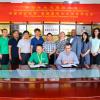 Yuqi Zhao, president of Qimei, left, and Martin Wiedmann, sign an agreement to collaborate on microbial food safety research while participants look on