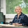 Renata Ivanek sitting at a desk in front of a window